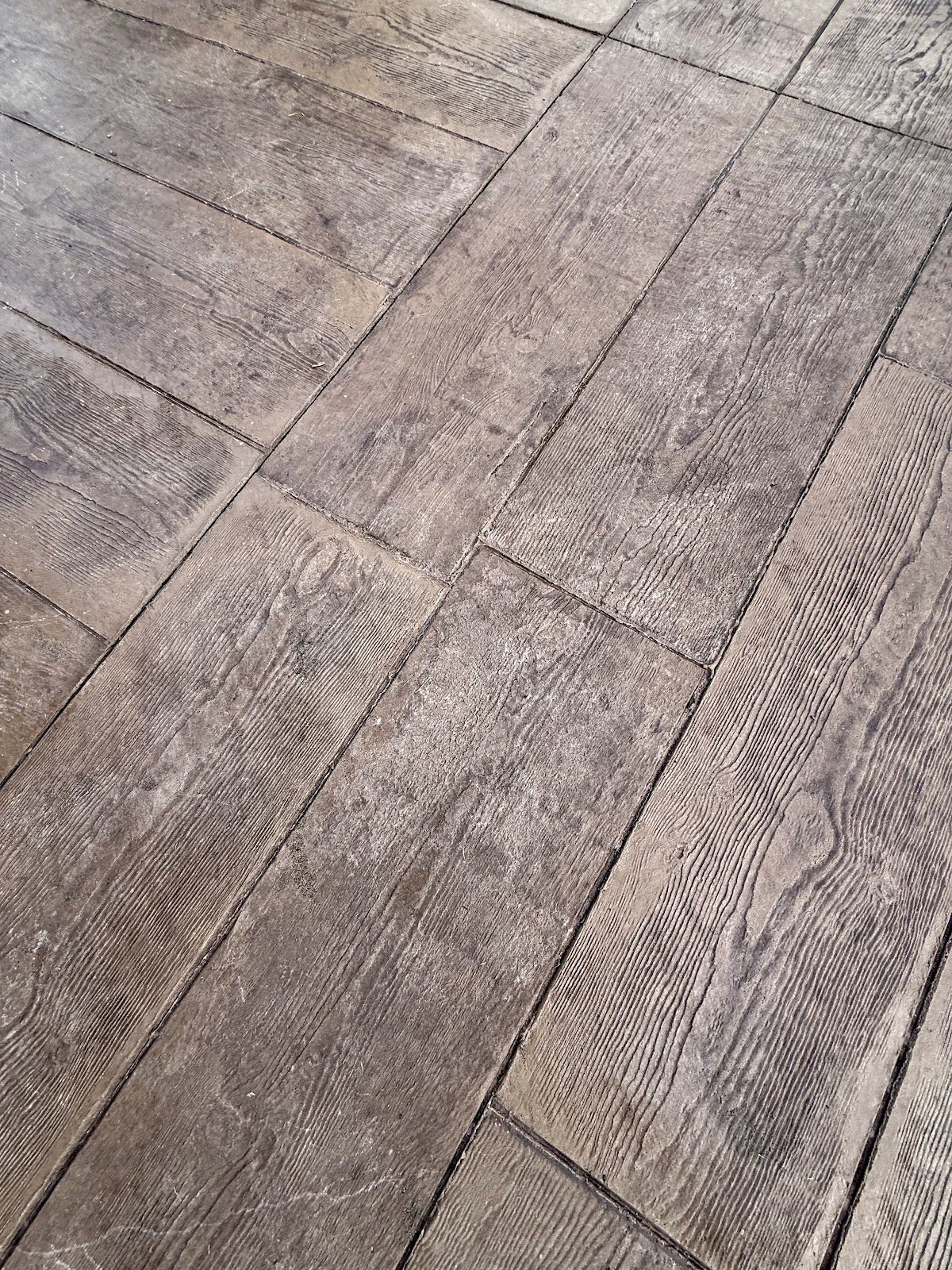 Close-up of wood-grain texture stamped into a concrete patio